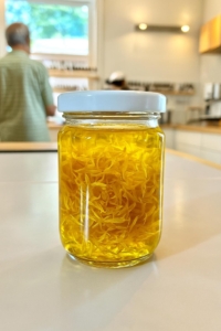 Ringelblumen_Oel_Mittig Durchsichtiges Glas mit orangen Ringelblumen in Öl eingelegt.