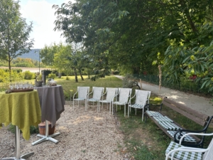 ein Garten mit Stühlen und einem Stehtisch mit Apero