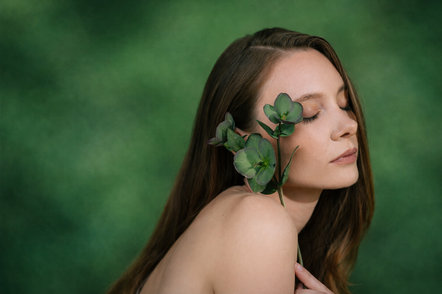 Frau von der Seite mit einem grünen blatt vor der Wange